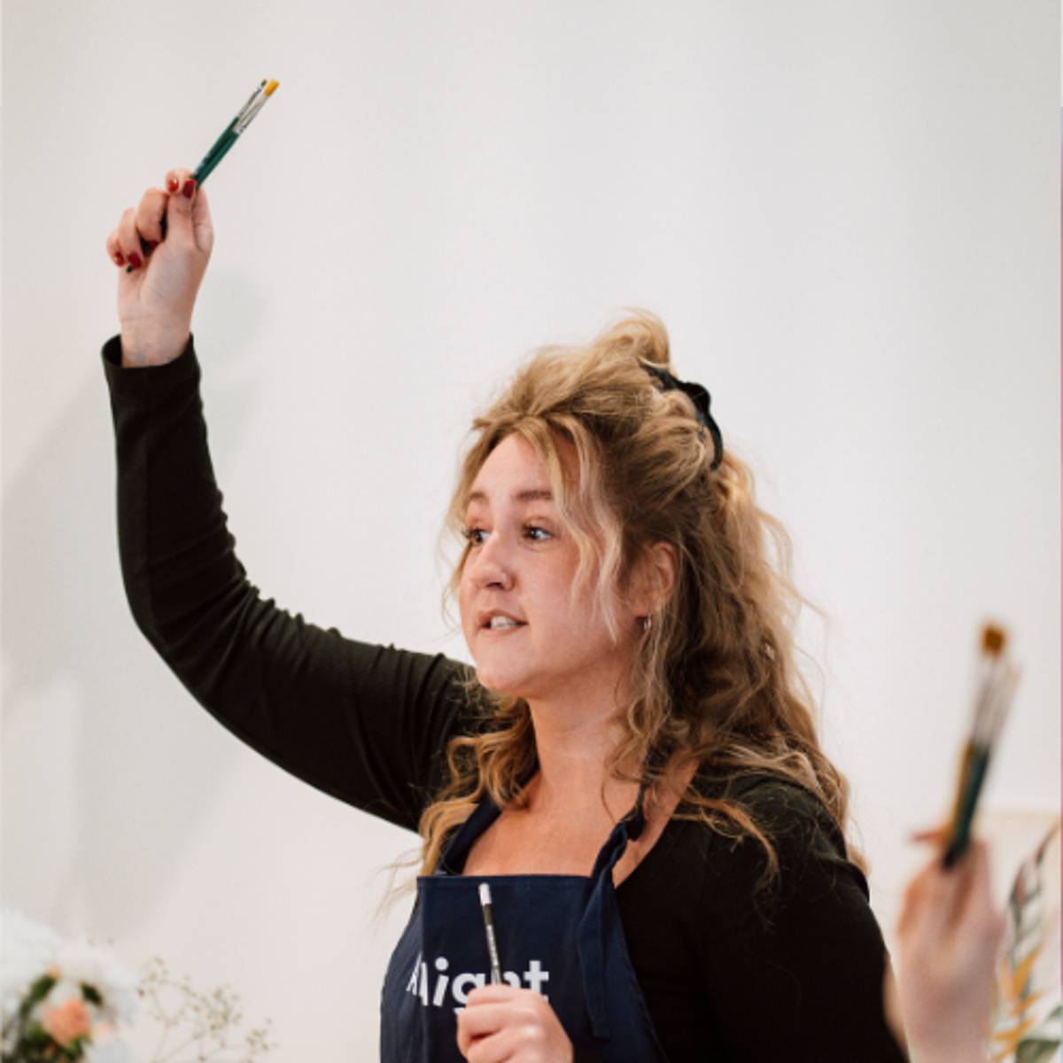 Ein ArtNight-Künstler erklärt seinen Teilnehmern etwas.