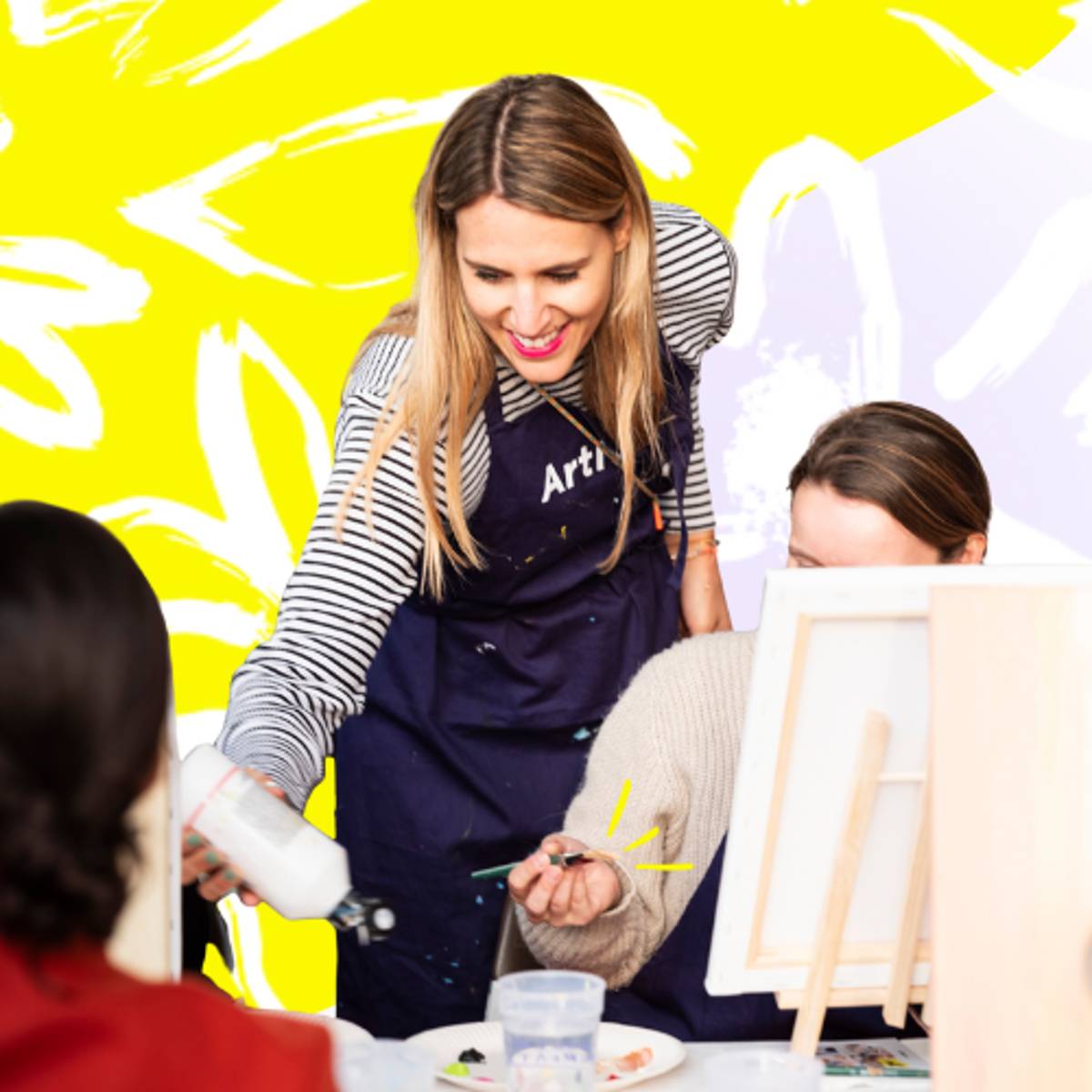 Aimie, Gründerin und CEO von ArtNight, schüttet bei einer ArtNight-Veranstaltung mehr Farbe für einen Teilnehmer aus.