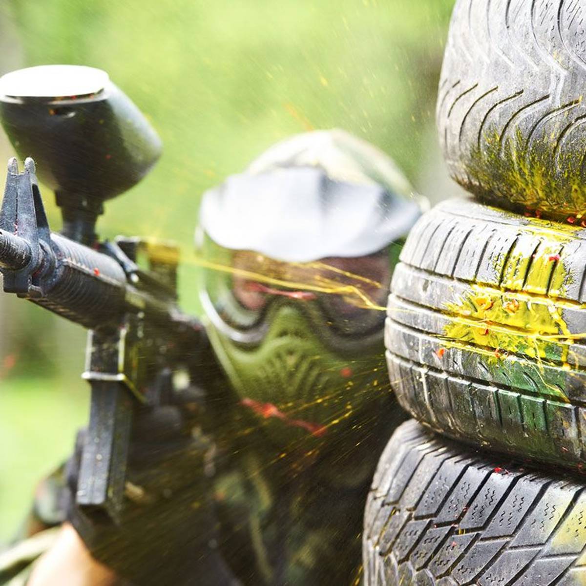 Geschützter Mann spielt bei einem Teamevent Paintball Geschützter Mann spielt bei einem Teamevent Paintball