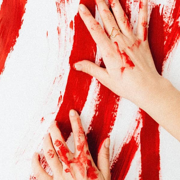 Hände verstreichen rote Farbe Hände verstreichen rote Farbe