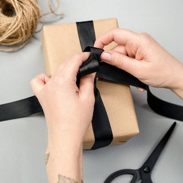 Ein Geschenk wird zugeschnürt Ein Geschenk wird zugeschnürt