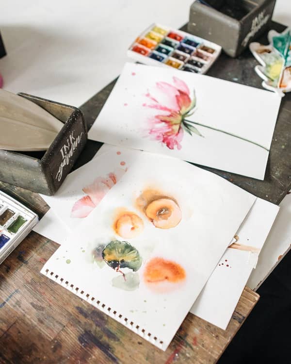 Aquarellbilder auf einem unordentlichen Tisch verteilt