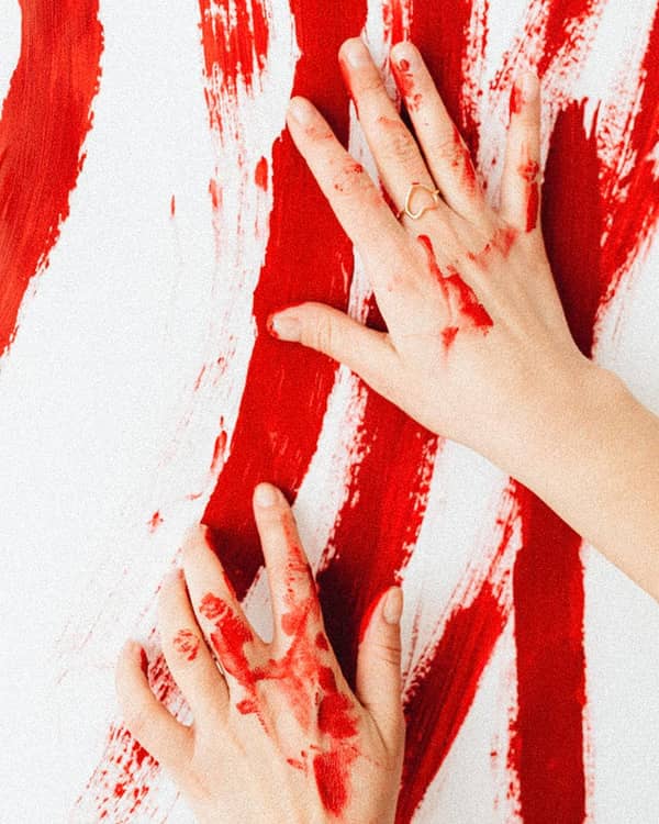 Hände verstreichen rote Farbe