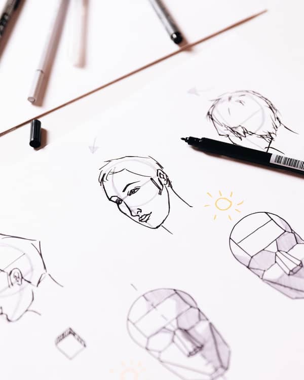 unterschiedliche Porträts werden auf einem Blatt Papier gezeichnet