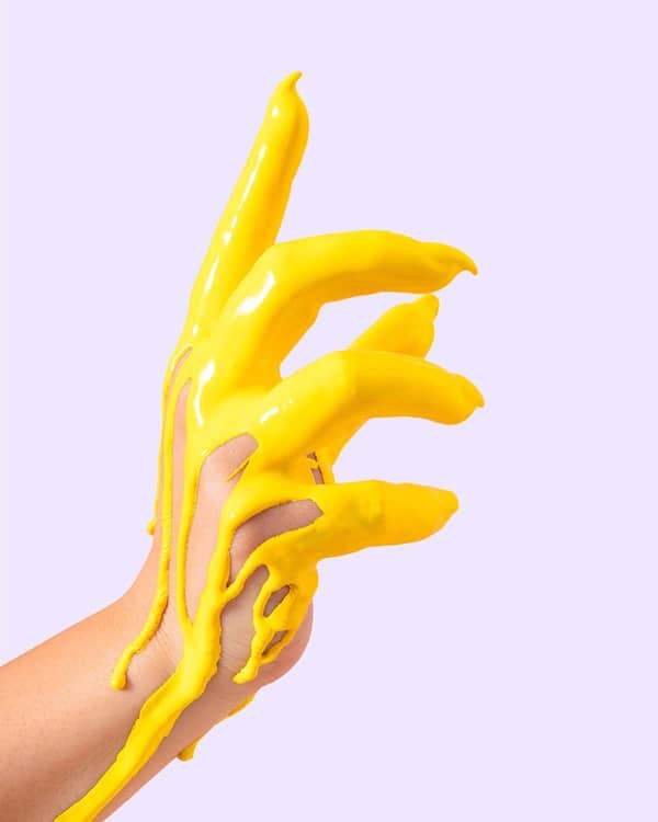 Hand in gelbe Farbe eingetaucht