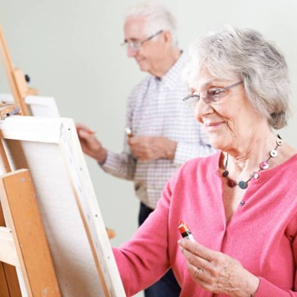 Senioren malen bei einer ArtNight freudig ein Bild