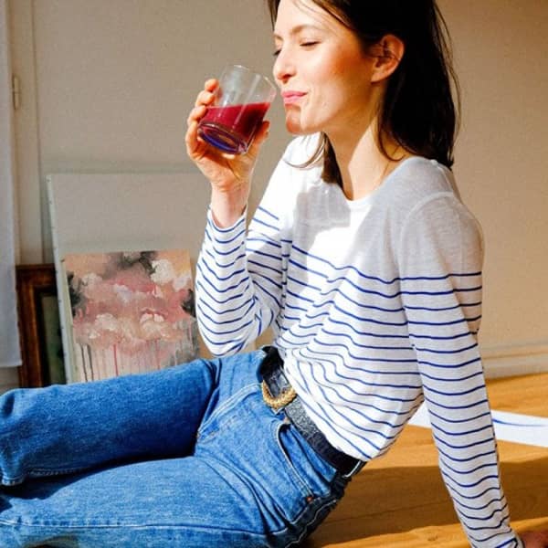 Eine Frau trinkt beim Malen etwas