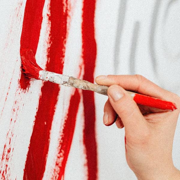 rote Farbe wird auf eine Leinwand aufgetragen