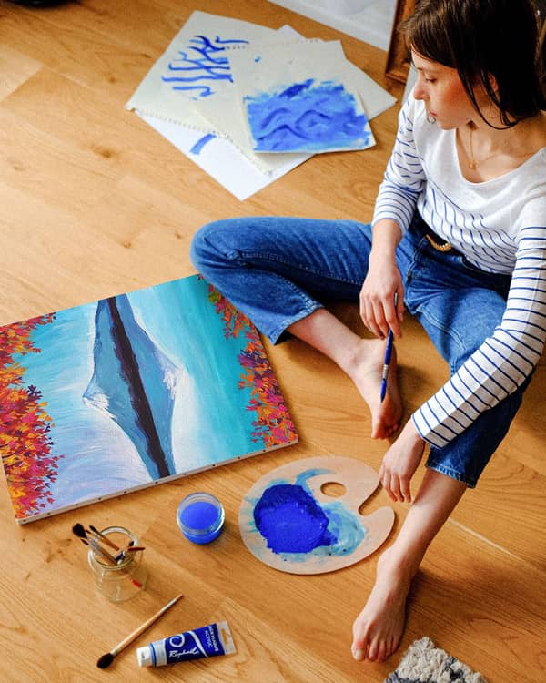 Frau malt auf dem Boden entspannende Bilder