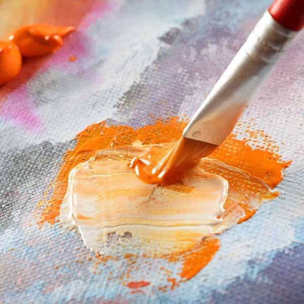 Orange Farbe wird auf einer Leinwand gemischt