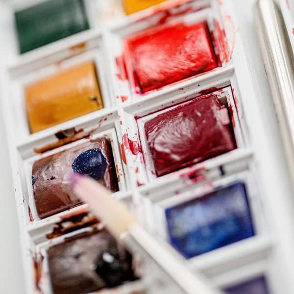 Ein Pinsel nimmt eine Aquarellfarbe auf